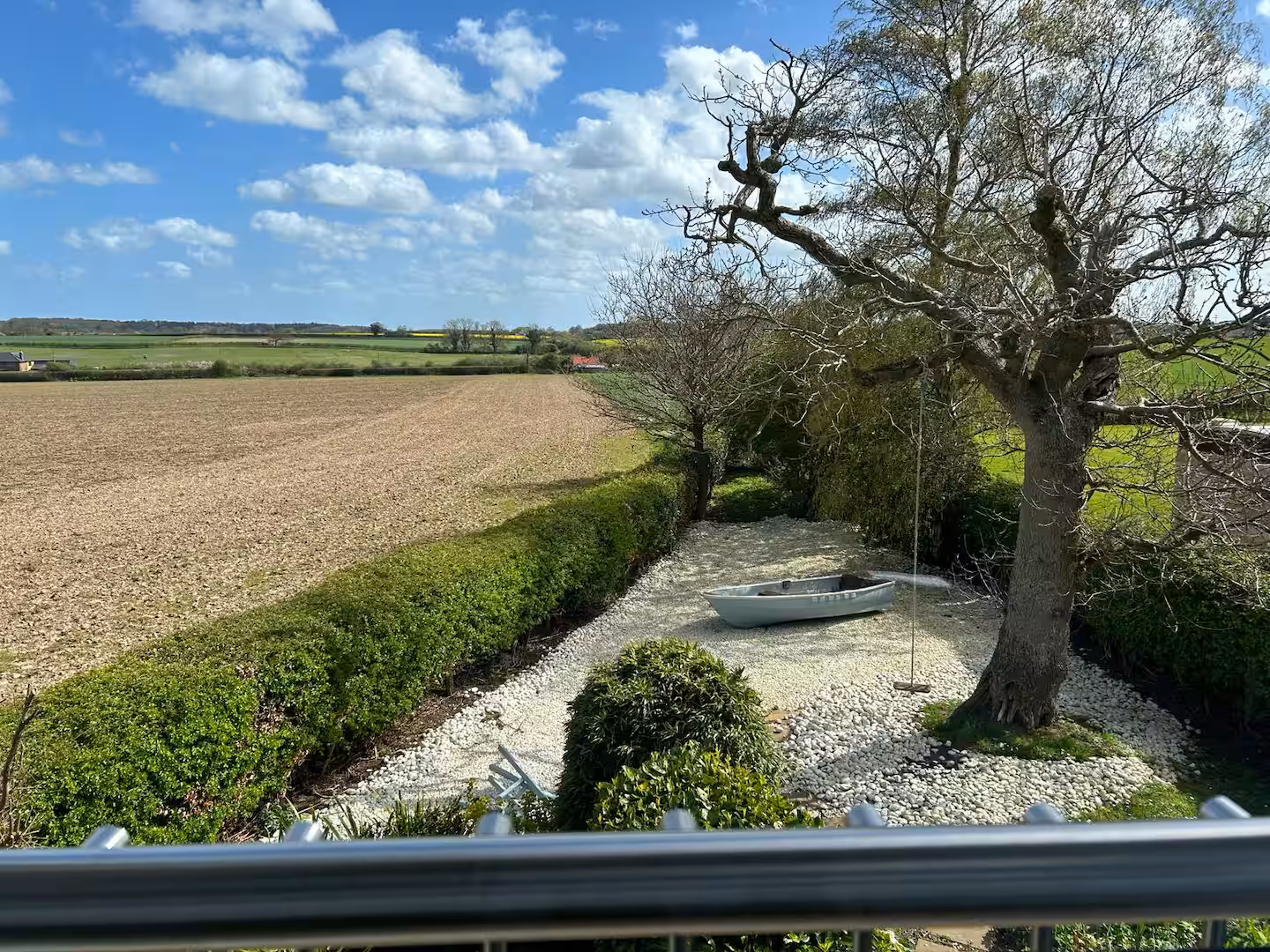 The garden and open fields beyond the hedge